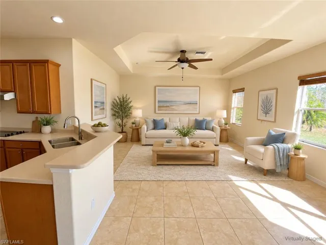 Kitchen featuring wood-finish cabinetry, stainless steel double-basin sink, and a breakfast bar