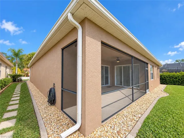 Screened-in patio with concrete flooring and ceiling fan