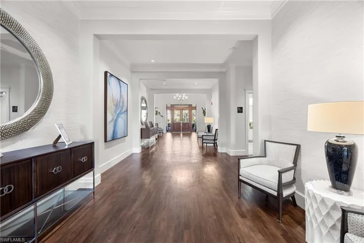 Corridor featuring dark wood-style floors and ornamental molding