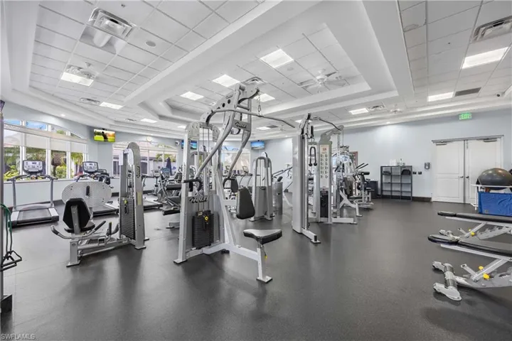 Gym featuring a drop ceiling and a raised ceiling