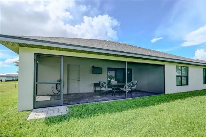 Rear view of property featuring a yard and a patio