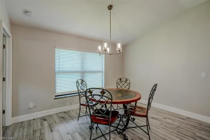 Dining room featuring light wood-type flooring and a notable chandelier
