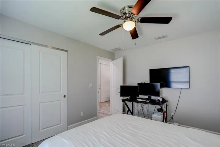 Bedroom with a closet, light hardwood / wood-style floors, and ceiling fan