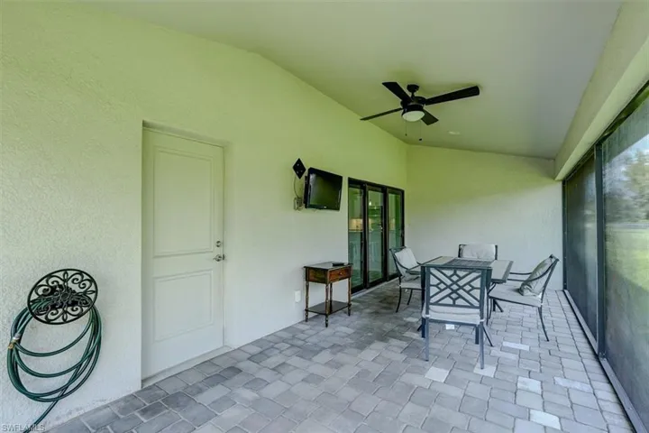 Unfurnished sunroom with vaulted ceiling and ceiling fan