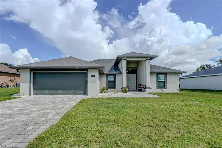 View of front facade featuring a front lawn and a garage