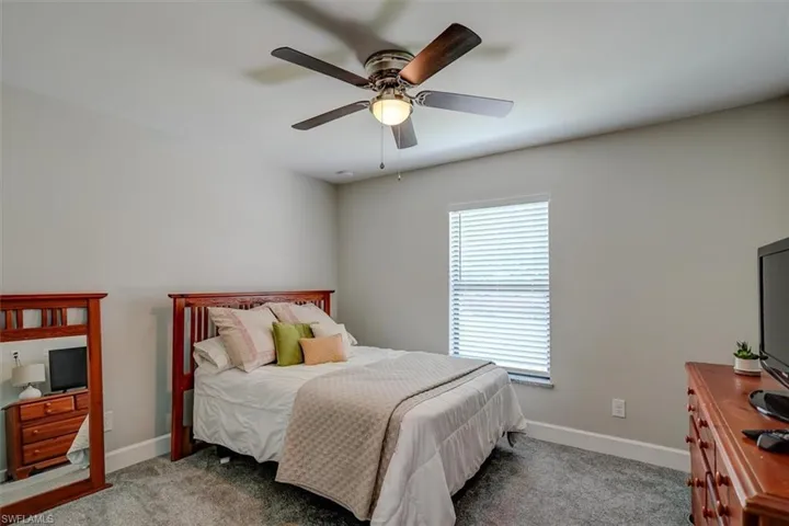 Carpeted bedroom featuring ceiling fan