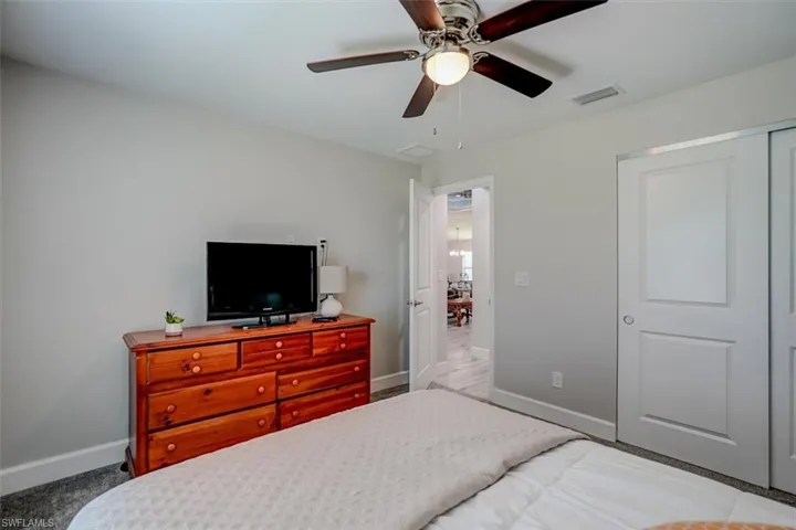 Carpeted bedroom featuring a closet and ceiling fan