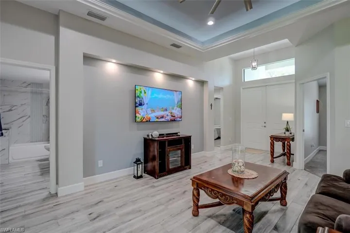 Living room featuring light hardwood / wood-style flooring and a high ceiling