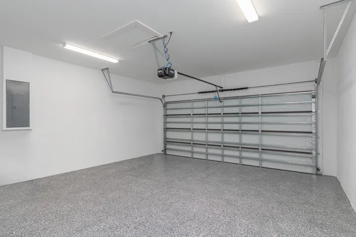 Garage featuring a garage door opener and electric panel