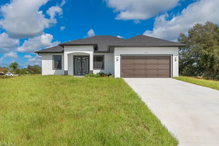 View of front of home with a garage and a front lawn