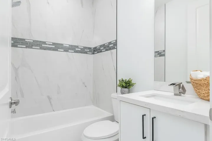Full bathroom with vanity, toilet, and tiled shower / bath