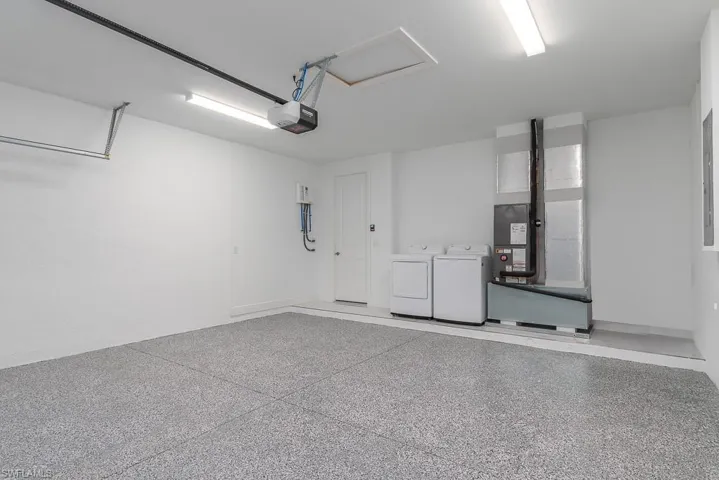 Garage with a garage door opener and washing machine and clothes dryer