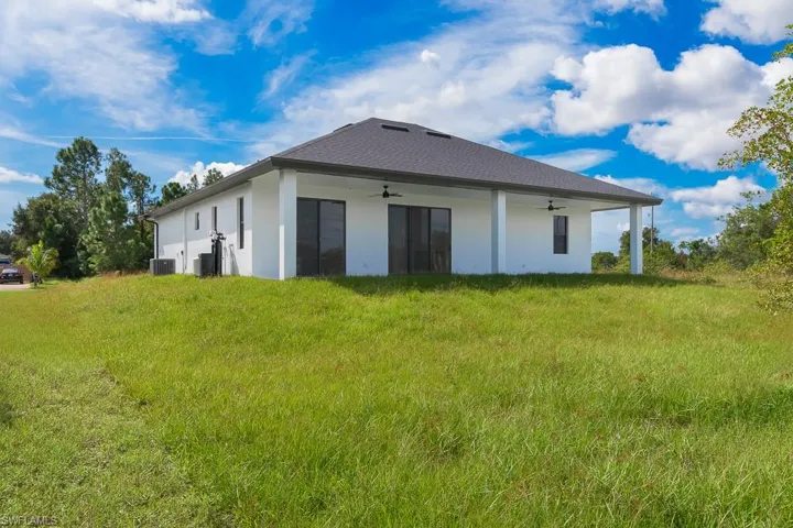 Back of property with ceiling fan and central AC