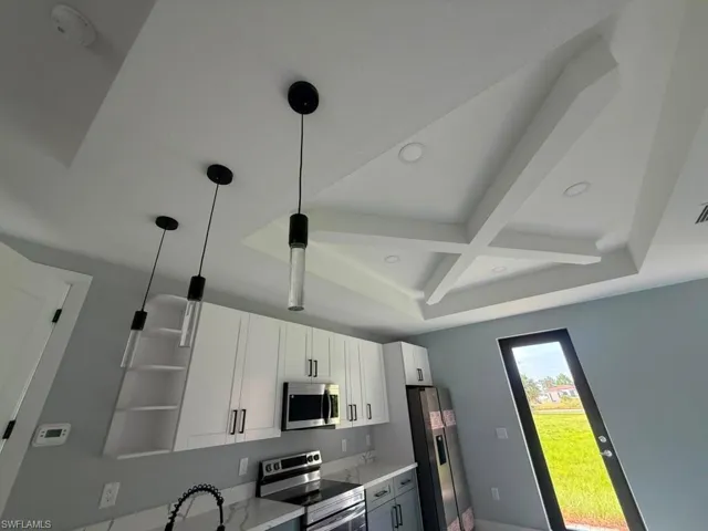 Kitchen featuring a decorative coffered ceiling with recessed lighting and three pendant lights