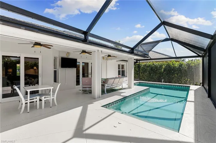 Swimming pool featuring a sunroom, a lanai, a patio, outdoor dining area, and outdoor lounge area