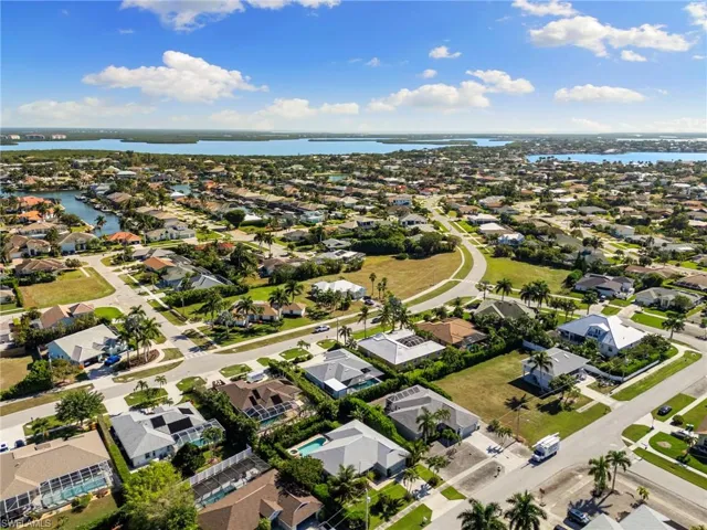 Aerial perspective of suburban area featuring a nearby body of water