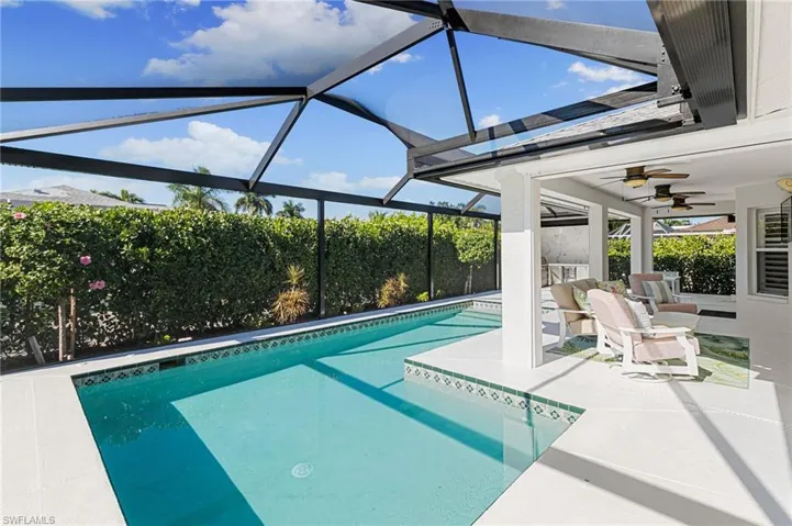View of pool with a patio, glass enclosure, and a sunroom