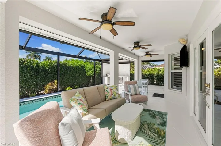 Sunroom / solarium featuring outdoor lounge area, a ceiling fan, and a patio area