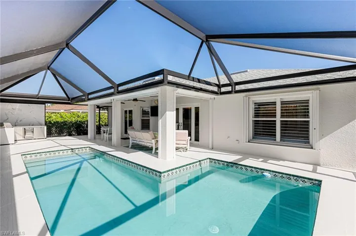 Swimming pool with a sunroom, a lanai, and a patio area