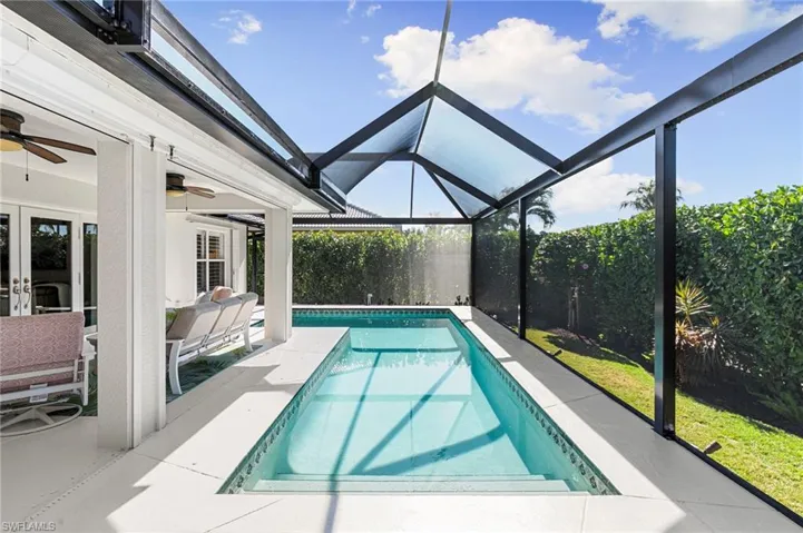 Swimming pool with a sunroom, a lanai, a patio, and french doors