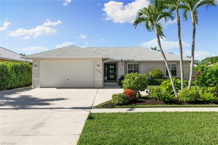 Ranch-style house with stucco siding, concrete driveway, a front yard, a garage, and a shingled roof