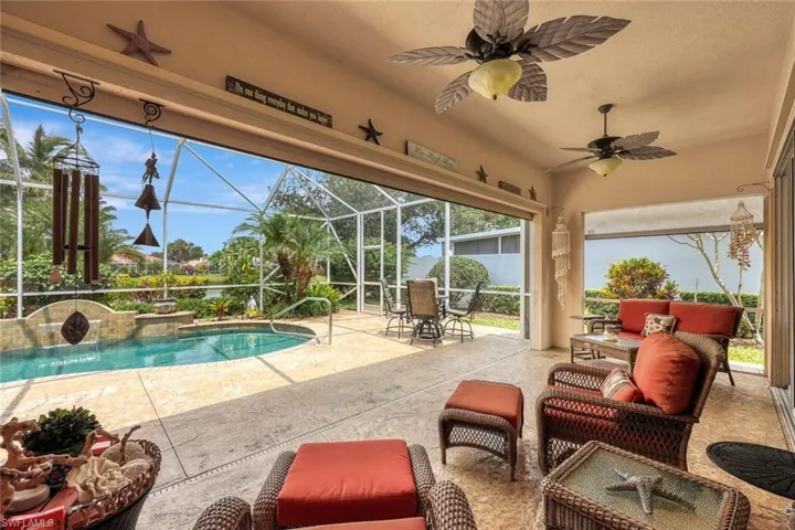 View of swimming pool with ceiling fan, pool water feature, an outdoor hangout area, a patio area, and glass enclosure