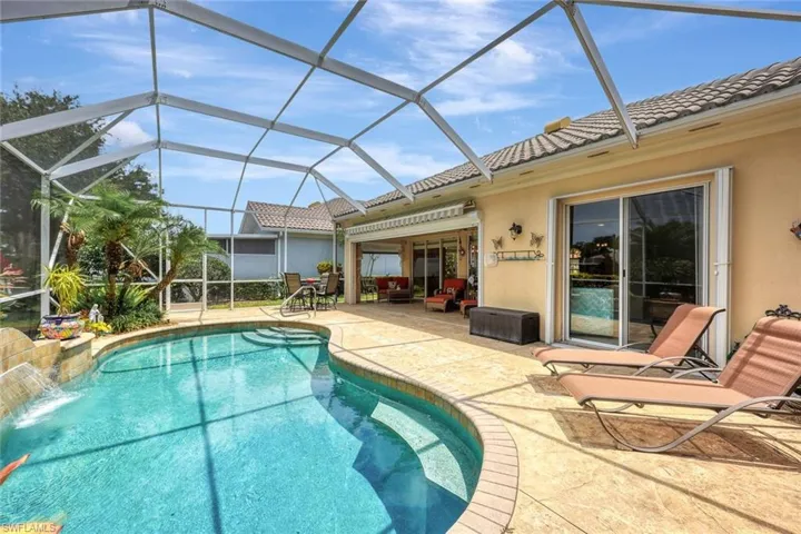 View of swimming pool featuring a lanai, a patio area, and pool water feature