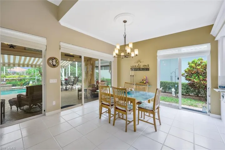 Tiled dining room featuring a notable chandelier and crown molding