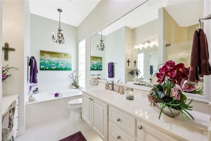 Bathroom featuring a bath, tile flooring, a healthy amount of sunlight, and oversized vanity
