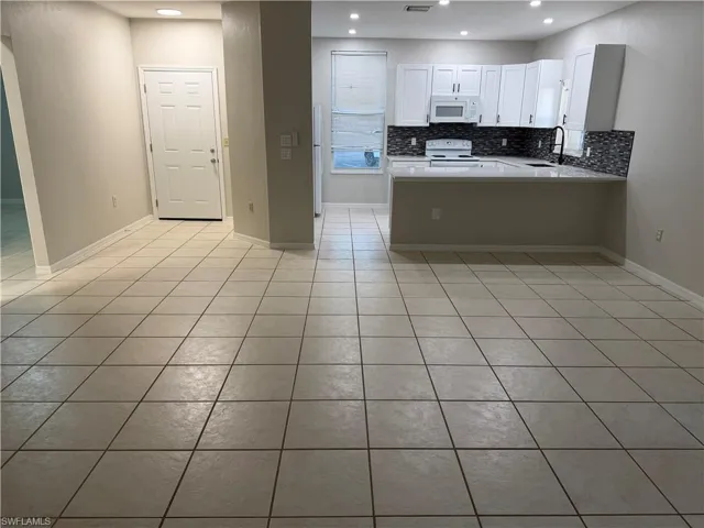 Spare room with a ceiling fan and light tile patterned floors