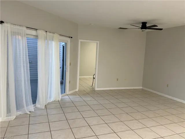 Empty room featuring a ceiling fan and light tile patterned flooring