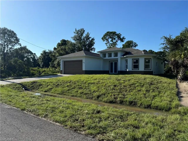 View of front of property with a front lawn and a garage