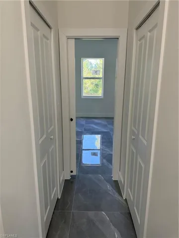 Corridor with dark tile patterned flooring