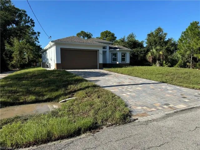 Ranch-style house with a garage, central AC unit, and a front yard