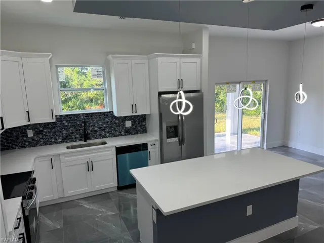 Kitchen with white cabinetry, appliances with stainless steel finishes, and sink