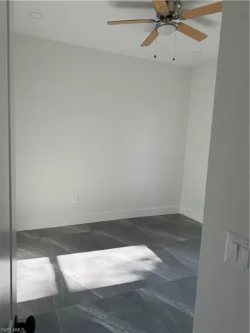 Unfurnished room featuring tile patterned floors and ceiling fan