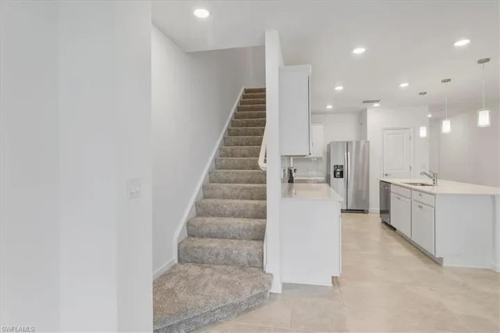 Stairs featuring tile patterned floors, recessed lighting, and baseboards