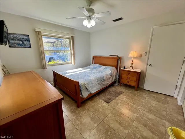 Guest Bedroom featuring ceiling fan and tile floors.