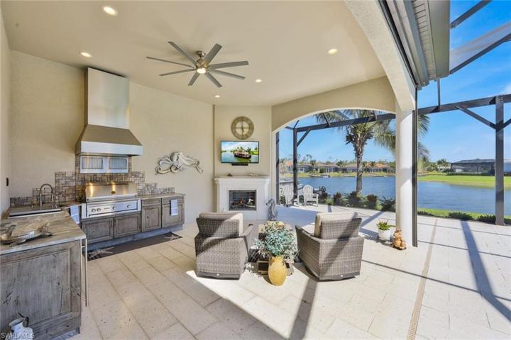 Outdoor Living room/Summer kitchen with Gas Fireplace, Grill, icemaker chest protected by kevlar transparent electric hurricane screens.