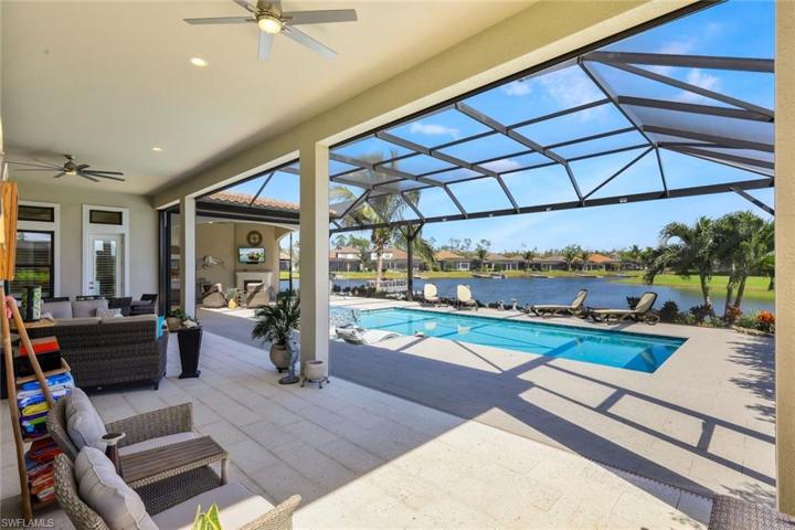 View of pool, picture window cage screens, lake, large covered lanai with electric Kevlar Hurricane screens and separate 2nd lanai/outdoor living room to left of pool!