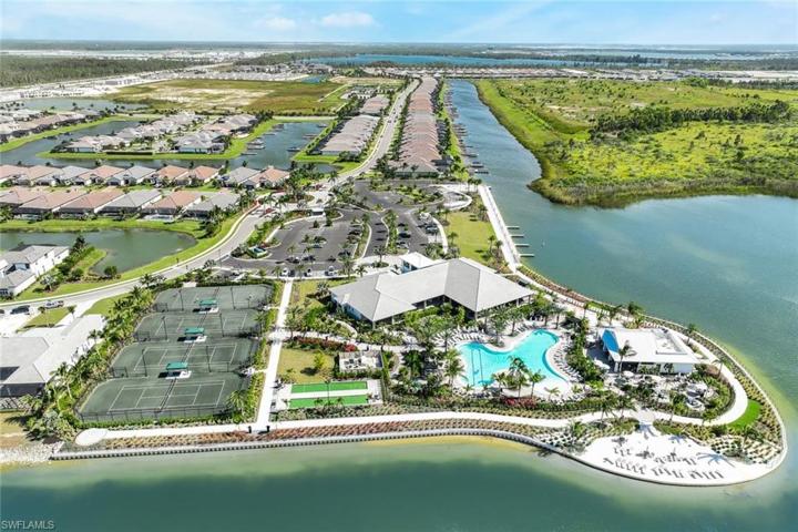 Aerial view of main amenity center with tennis, fitness center, bocce, beach and restaurant, parking and boat launch.