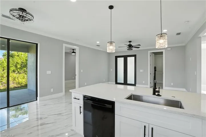 Kitchen featuring dishwasher, a ceiling fan, crown molding, recessed lighting, and light marble finish floors