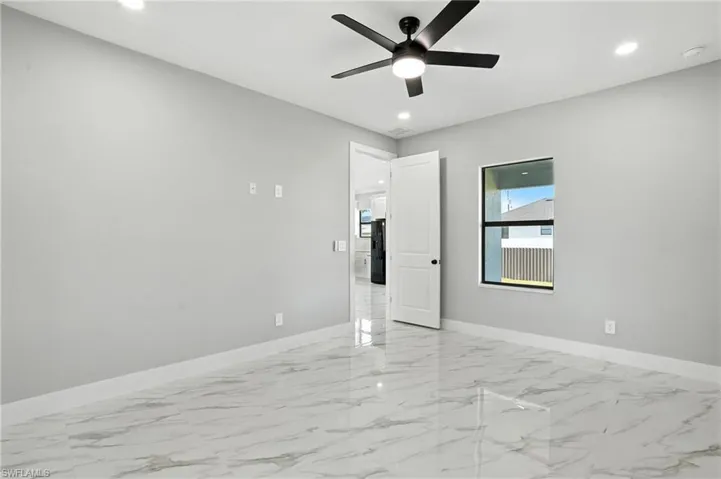 Empty room with a ceiling fan, light marble finish floors, recessed lighting, and a smoke detector