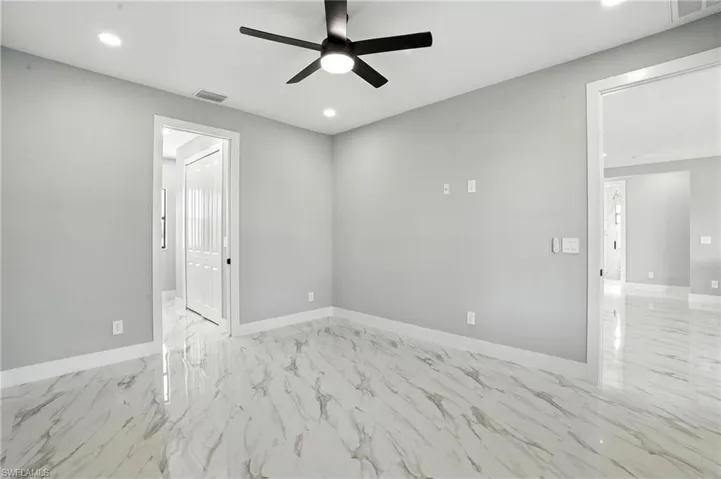 Spare room with marble finish flooring, a ceiling fan, and recessed lighting