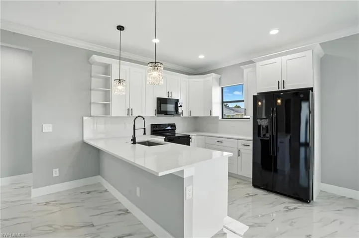 Kitchen featuring black appliances, a peninsula, open shelves, white cabinets, and light marble finish flooring