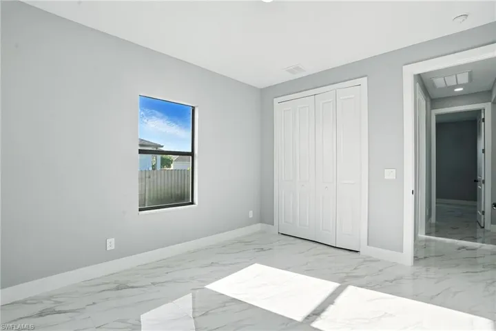 Unfurnished bedroom featuring marble finish flooring and a closet