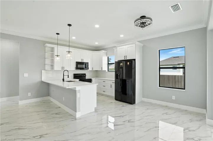 Kitchen with black appliances, a peninsula, open shelves, ornamental molding, and recessed lighting