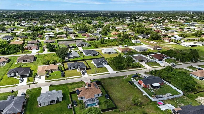 Aerial view of property and surrounding area featuring nearby suburban area