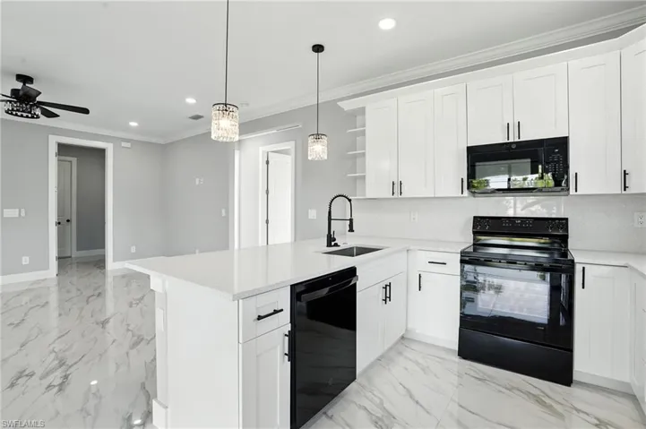 Kitchen with black appliances, open shelves, recessed lighting, ornamental molding, and light marble finish flooring