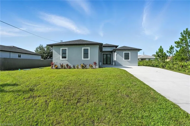 View of front of house with stucco siding and driveway